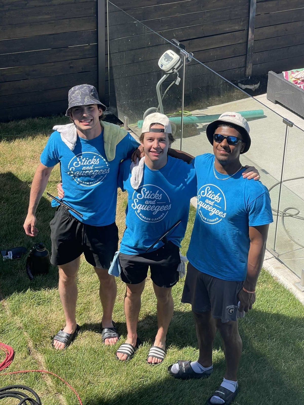 The Sticks & Squeegees crew in branded shirts on a job