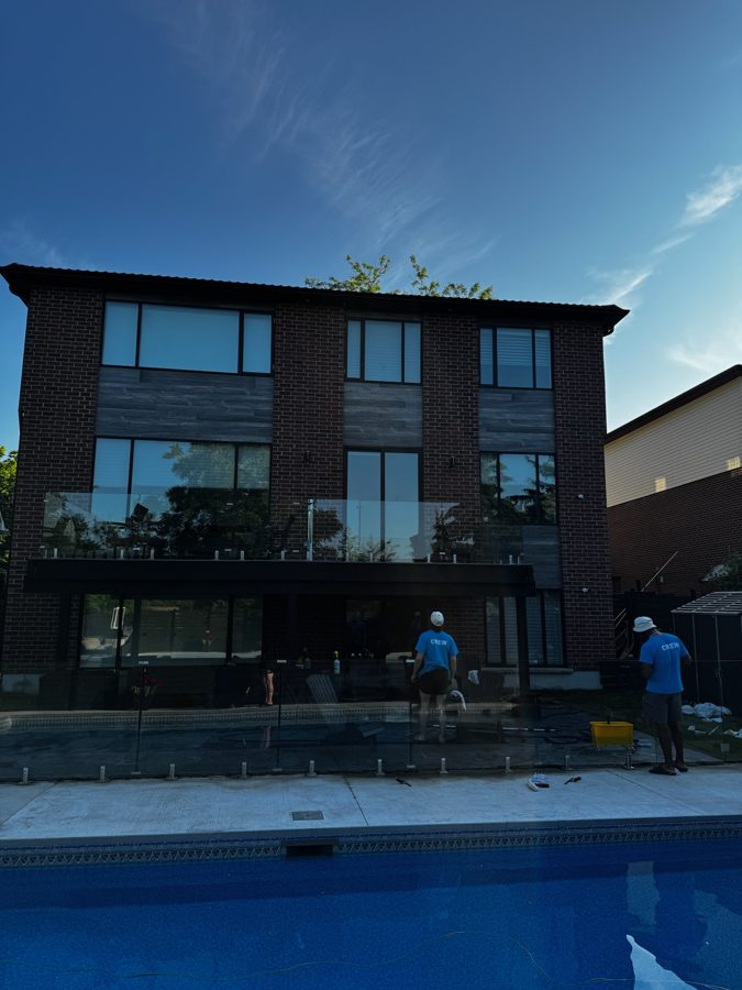 The Sticks & Squeegees crew cleaning windows at a poolside Oakville home